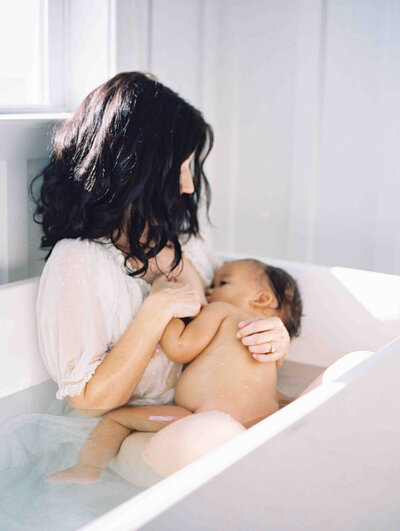 Richmond Family Photographer | Film image of a mother breastfeeding her baby in a bathtub by Jacqueline Aimee Portraits