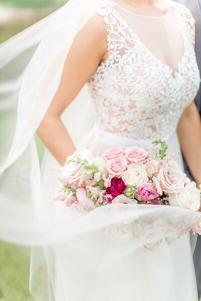 bride in a wedding gown holding a bouquet with pink flowers
