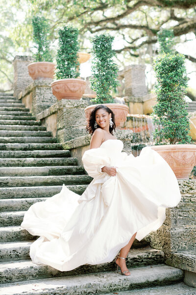 Stunning bride in ballgown wedding dress dances down stairs