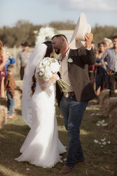 This image is of a couple kissing during wedding ceremony.