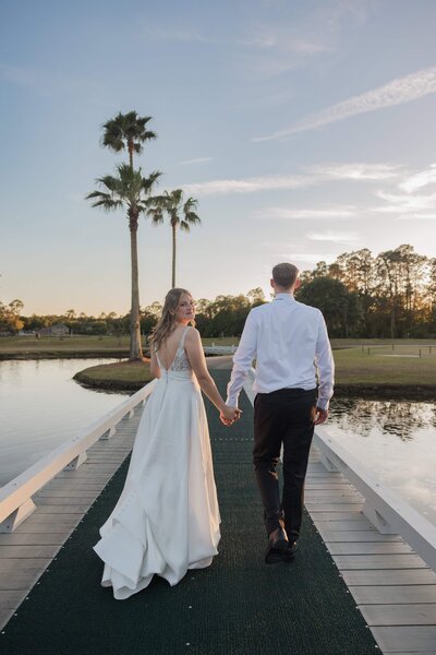 Phavy Photography, a Jacksonville wedding photographer specializing in Catholic weddings, captured this serene sunset moment of the bride and groom walking along a peaceful dock. The bride’s elegant gown and the golden hour glow reflect a sense of grace and intention. Perfect for Catholic couples seeking timeless, romantic imagery that honors both beauty and tradition in Jacksonville and beyond.