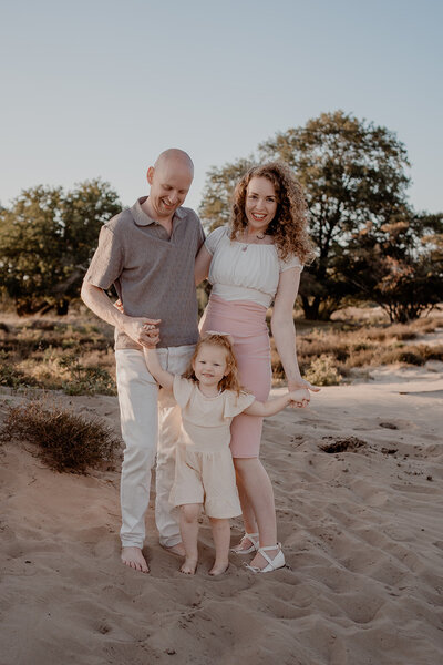Spelenderwijs moment tussen ouders en kinderen tijdens gezinsfotoshoot door Leukfotografie in Soesterduinen