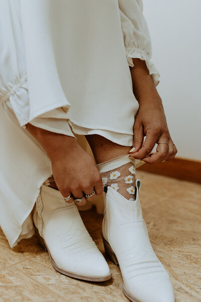 Bride pulling up decorative sock representing the playful and detail oriented photography style of Boise wedding photographer Shayne Center Photo.