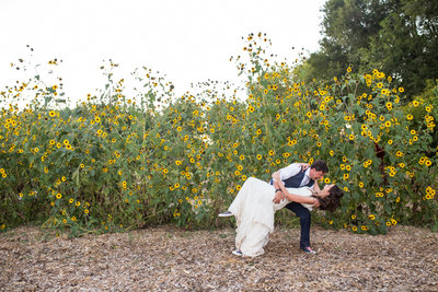 Bride and groom dancing in front of sunflowers for fall wedding in New Mexico