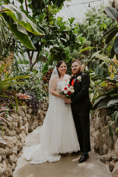 Bride and groom standing in the greenhouse at Miller Nature Center near Cleveland, Ohio