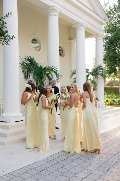 Group of Bridesmaids in butter yellow bridesmaids dresses talking and laughing