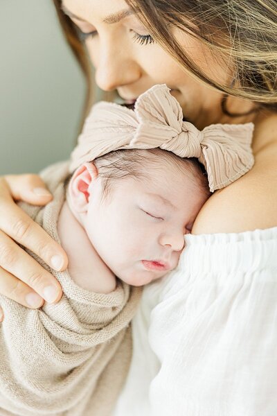 mom holding baby girl for newborn photos
