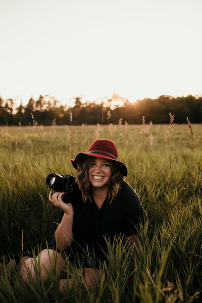 photographer holding camera in a wheat field