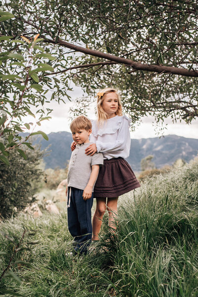 Blonde children in pose on hillside