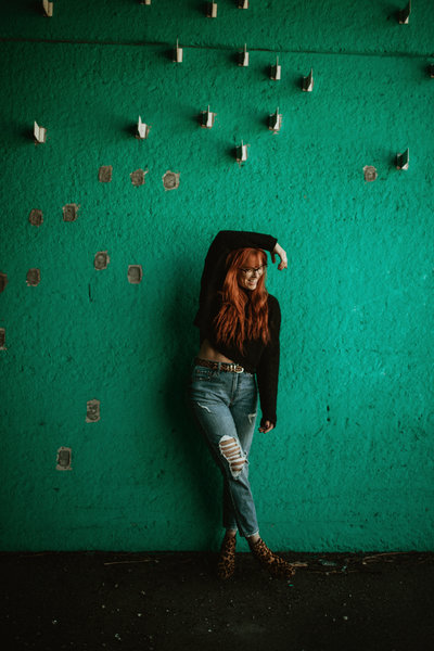 woman standing against green wall