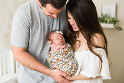 mom and dad holding newborn baby in lifestyle session