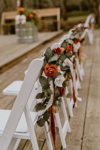 A line of earth toned floral decorated chairs for a wedding. 
