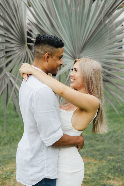 engaged couple on beach with plant