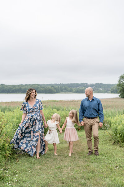 Picture of family walking in field, laughing together and holding hands