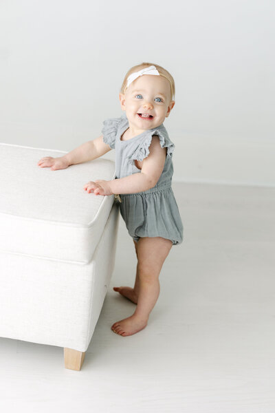 a baby smiling while standing in his crib