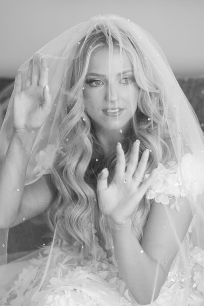A bride lifting a veil away from her face