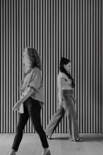 Calgary interior designers crossing a space with a striking wood-paneled feature wall, showcasing modern design aesthetics.