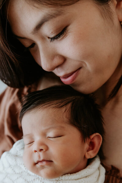 Close up of mother holding newborn baby