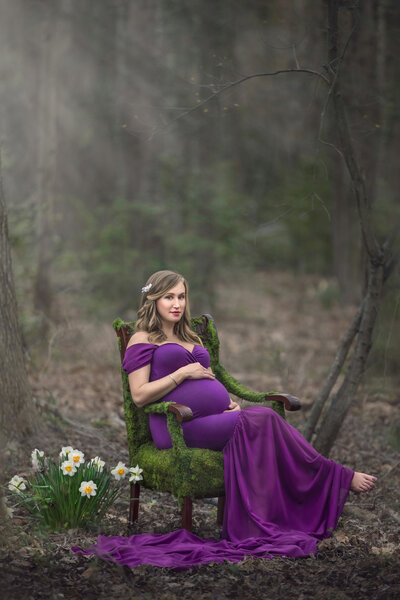 Pregnant woman holds belly for unique maternity photos in Sayen Gardens  in Hamilton, New Jersey.