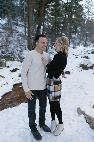 A couple makes each other laugh on a snowy day in North Cheyenne Canon Park. 