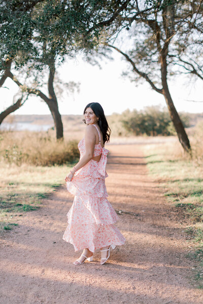 Malibu photographer capturing senior portraits at golden hour in coastal field.