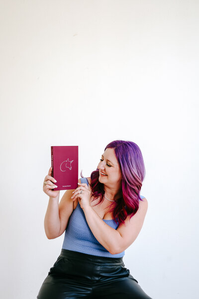 Photography Business Coach | Karinda K | Karinda holding her Unicorn Book for Photographers