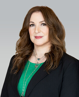 Headshot of entertainment attorney and Film & Ink Law Group Partner, Ellen Waggoner. She has long brown hair and is wearing a black blazer and emerald green blouse.