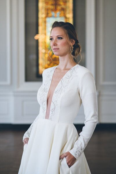 Link to more details and photos of the Iman modern ballgown wedding dress style with its long sleeves and sexy plunging neckline.