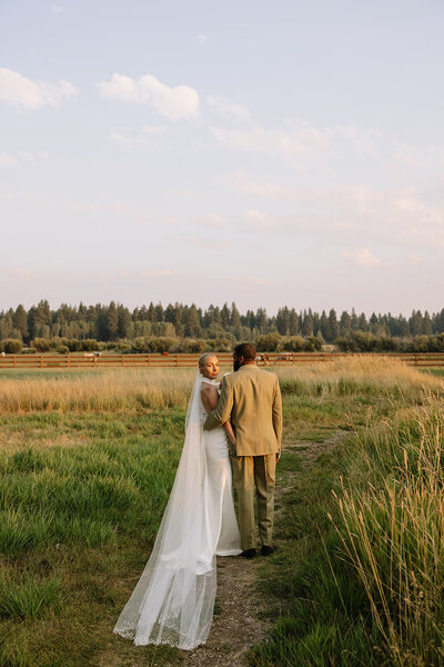 bride and groom holding hands while their bridal party is standing around them