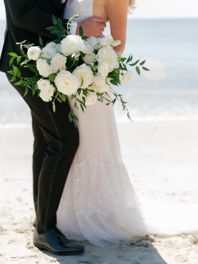 Modern wedding bouquet with vibrant pink ranunculus, garden roses, and delicate greenery by Leigh Florist, styled for a chic wedding ceremony.
