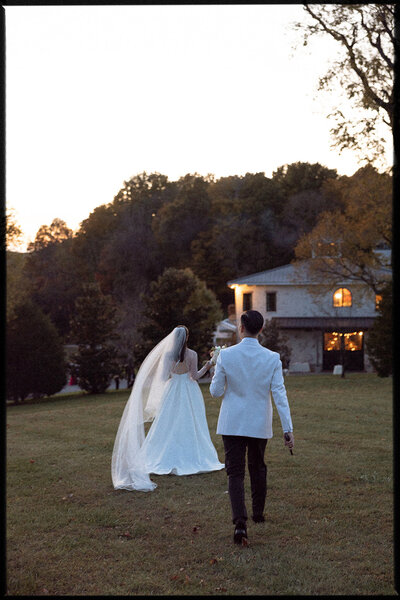Couple marches towards their wedding reception during blue hour on their wedding day at Trinity View Farm in Franklin, TN.