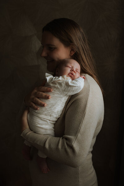 Mama omhelst baby tijdens newbornshoot