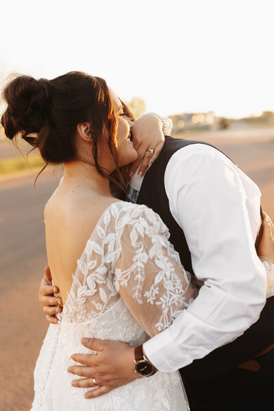 Bride and groom hugging during sunset