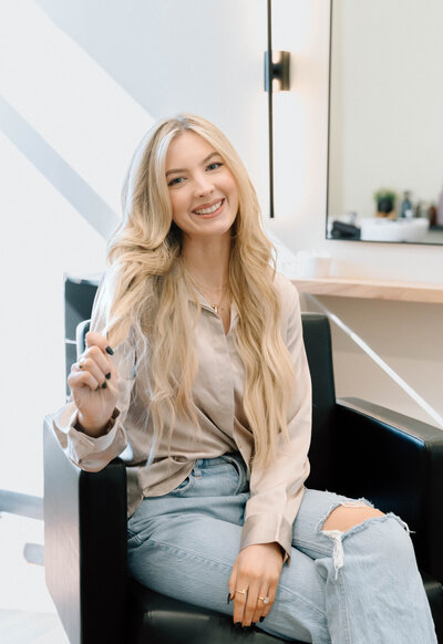 Katie, beauty provider at Lavender & Ink Studios, smiling in salon chair