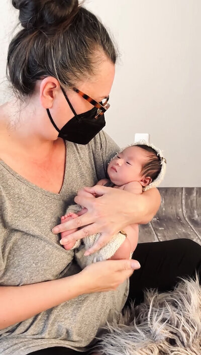 behind the scenes during a newborn photo session in shelby township mi while the photographer soothes baby to sleep