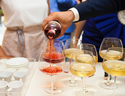 Red wine poured in wine glass and other glasses have white wine