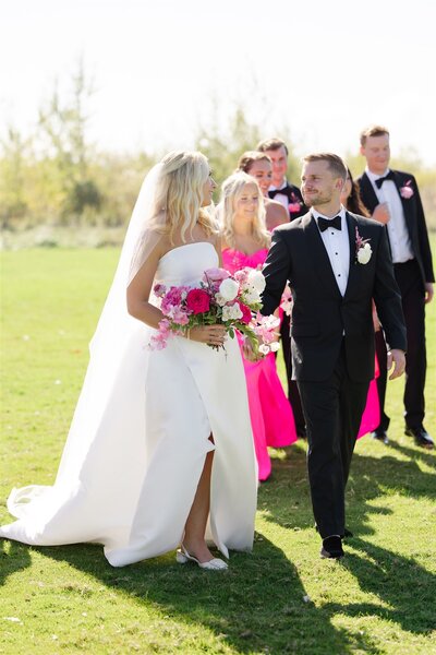 Bride and Groom walking together on Mackinac Island, in front of their bridal party