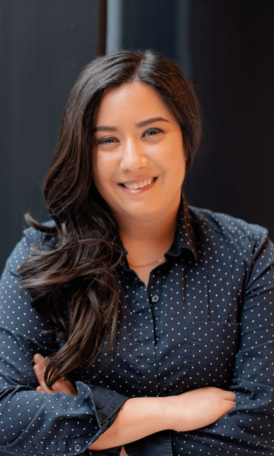 Mehroz Baig smiling in a modern, light-filled setting, representing her work as a strategist and storyteller.