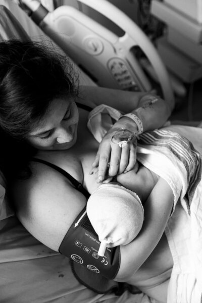 Black and white image of mother admiring her newborn’s tiny details during skin-to-skin after birth at Michael Garron Hospital in Toronto