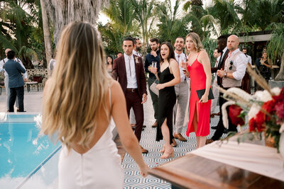 Bride and Groom walk through rays of sunshine to join their guests at their tropical reception at Floral Farms in Los Cabos Mexico