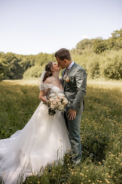 Bruidspaar kussend onder de sluier, trouwfotografie.