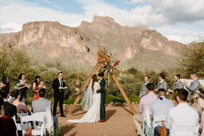 newlyweds kiss in front of arizona mountain