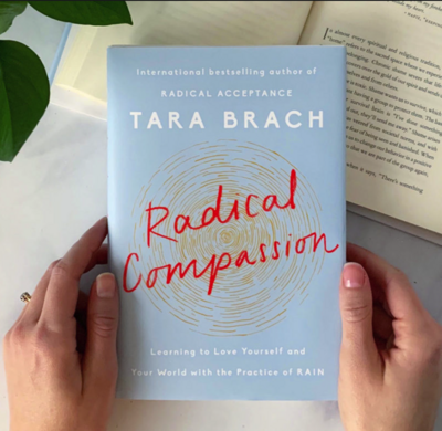 Woman holding the book "Radical Compassion"