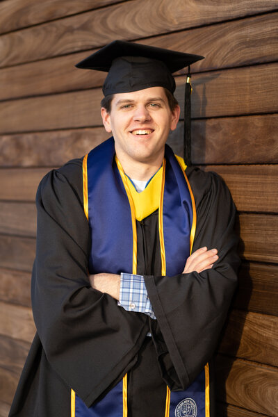 Young man posing in a cap and gown at graduation