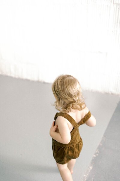 Child, wearing overall suspenders.