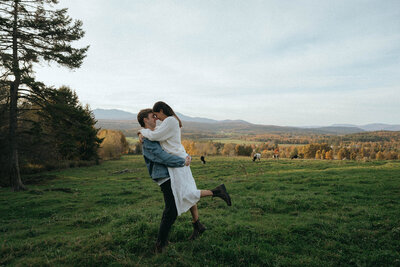 couples shoot in a field with cows captured by vermont wedding photographer elsie goodman