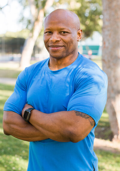 man with folded arms  smiling at camera