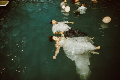 bride and groom floating in ocean