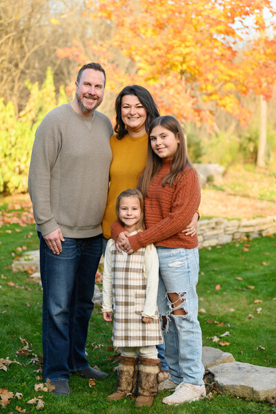 Mom and dad with their two daughters in the fall for their family photos in Burlington, ON