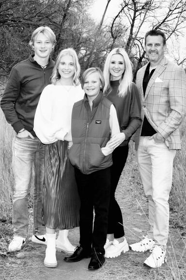 Lon Stroschein with his wife and three children, standing together in a wooded area